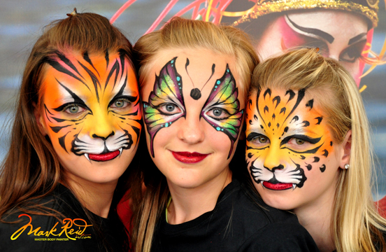 three girls in face paint two with a tiger theme and one with a butterfly theme
